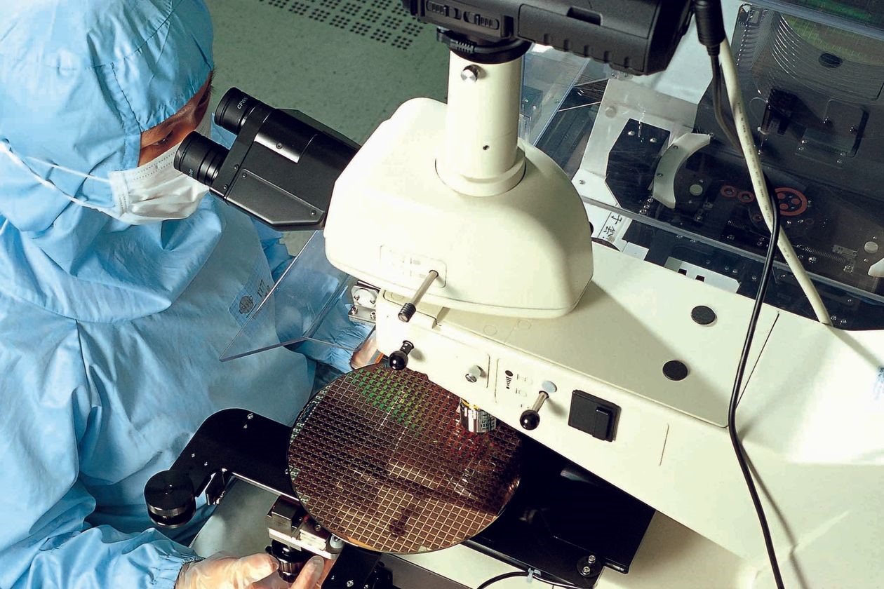 Một công nhân của TSMC với tấm wafer 8 inch.