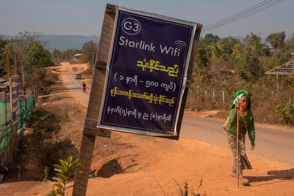 Một người phụ nữ đi qua một tấm biển quảng cáo WiFi Starlink ở Myanmar. Công ty cung cấp kết nối băng thông rộng cho hơn 5 triệu khách hàng ở 125 quốc gia. Ảnh: LightRocket/Getty Images/FT.